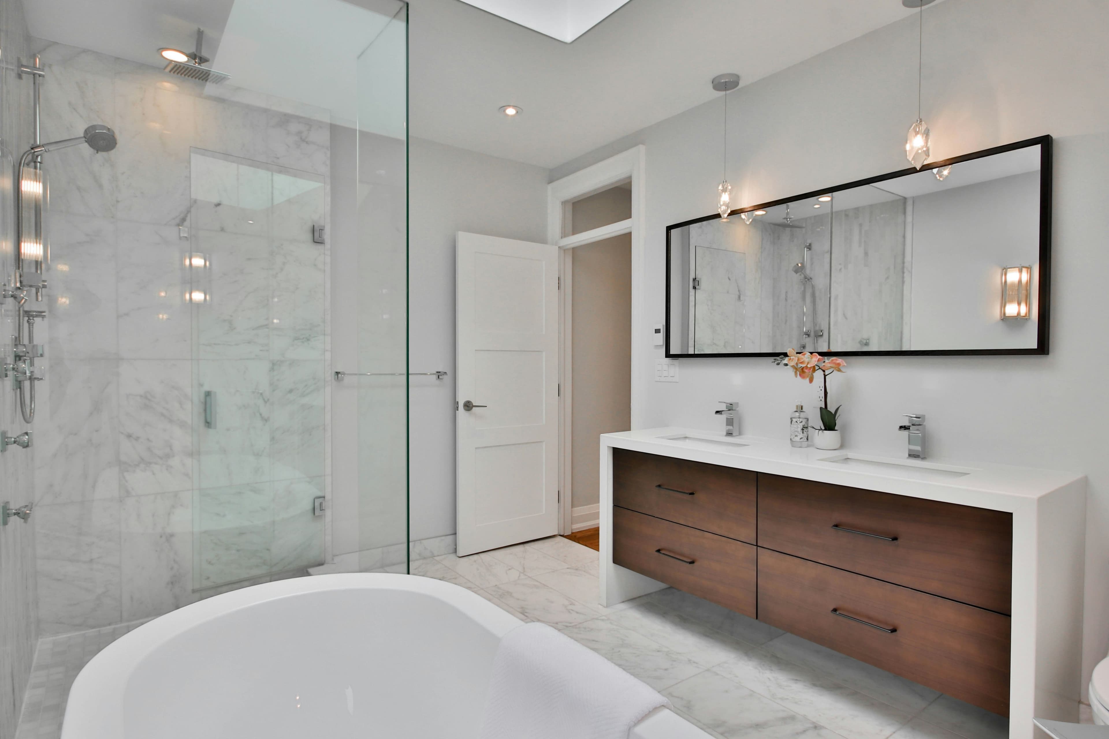 Luxury modern bathroom renovation with walk-in rain shower by Prime Renovation